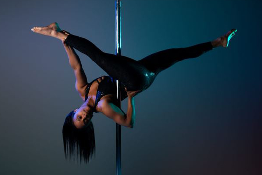 Instructor Shannel hanging upside-down from her outside leg.